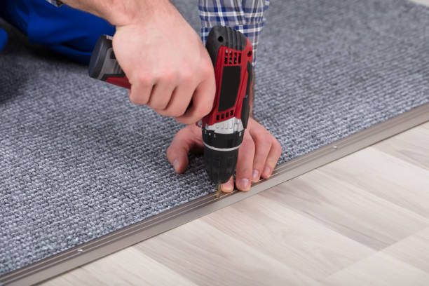 Close-up Of A Carpet Fitter's Hand Installing Grey Carpet With Wireless Screwdriver